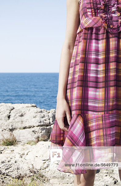 Spain  Mallorca  Young woman standing with sea in background