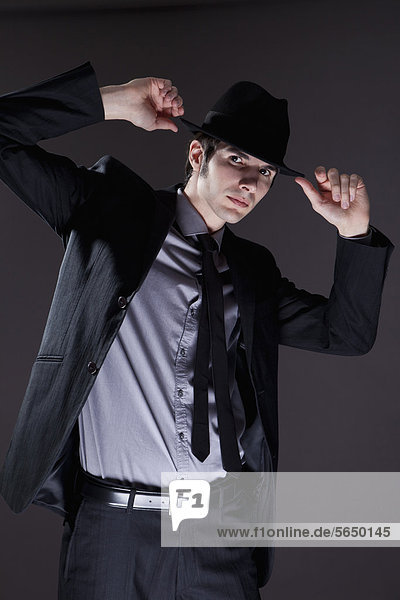 Junger Mann im schwarzen Anzug mit Hut  Portrait