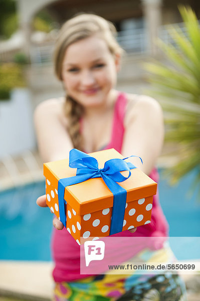Spanien  Mallorca  Teenager Mädchen mit Geschenkbox  lächelnd  Portrait
