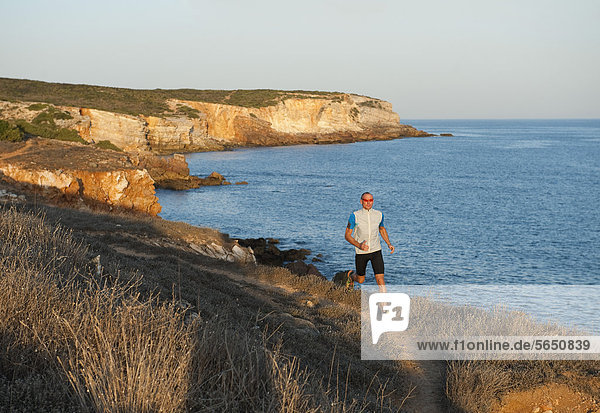 Portugal Algarve  Erwachsener Mann beim Joggen an der Küste
