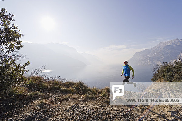 Italy  Mature man jogging by Lake Garda