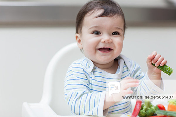 Baby boy eating healthy vegetables