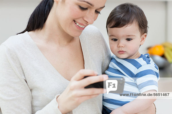 Mother and baby son looking at smartphone