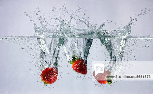 Erdbeeren  die ins Wasser fallen