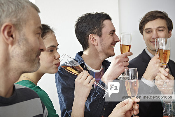 Men and women toasting with champagne in office