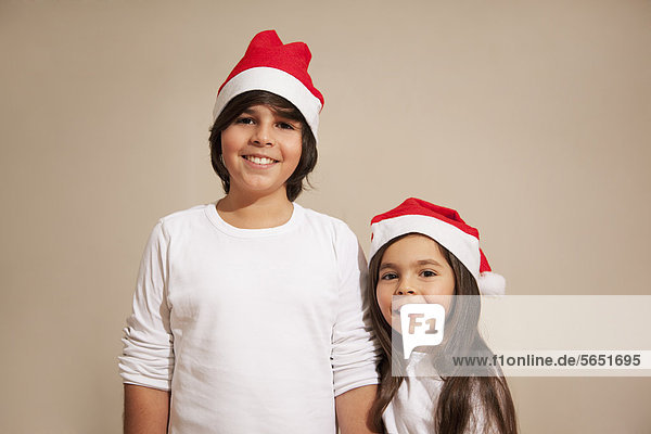Kinder mit Weihnachtsmütze,  lächelnd,  Portrait