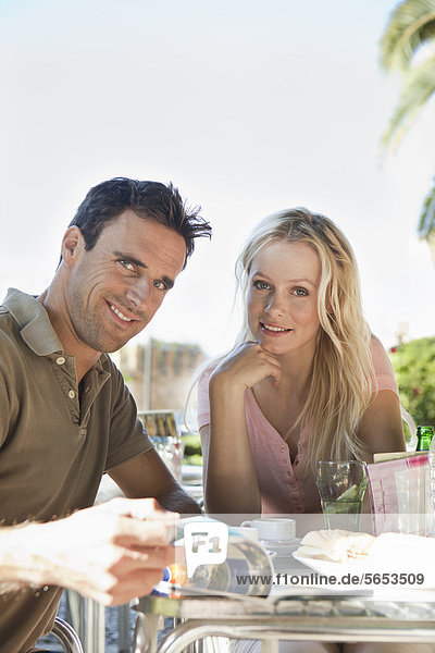 Spanien  Mallorca  Palma  Paar am Tisch sitzend im Café  lächelnd  Portrait