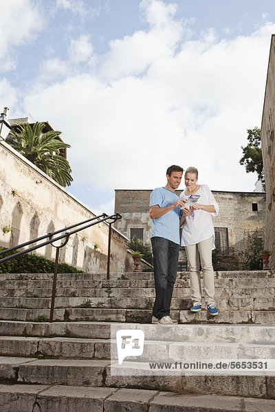 Spanien  Mallorca  Palma  Paar mit Reiseführer  lächelnd