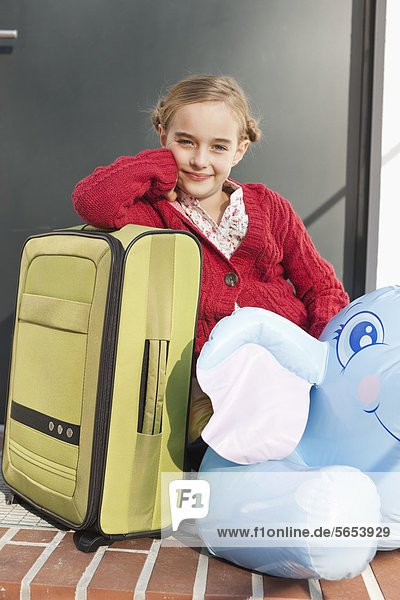 Mädchen mit gepacktem Gepäck  lächelnd  Portrait