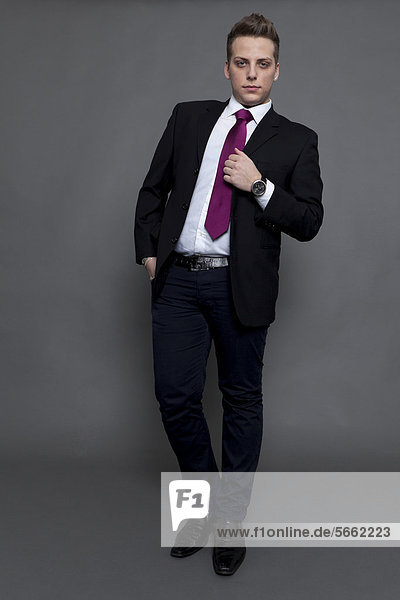 Junger Mann im Business-Look mit Anzug und Krawatte