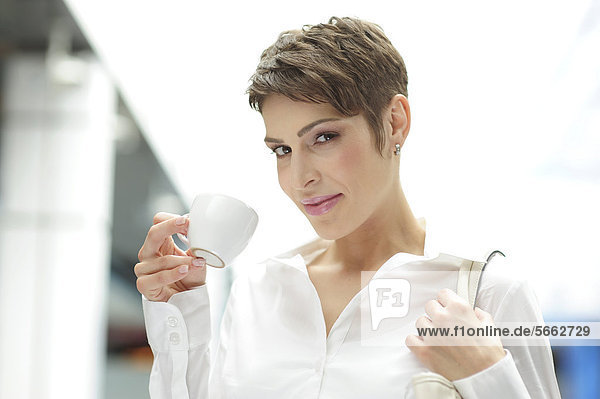 Junge Geschäftsfrau mit Tasse Kaffee