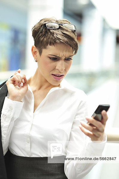 Junge Geschäftsfrau mit Mobiltelefon