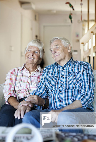 Verheiratetes Seniorenpaar sitzt auf dem Sofa im Wohnzimmer
