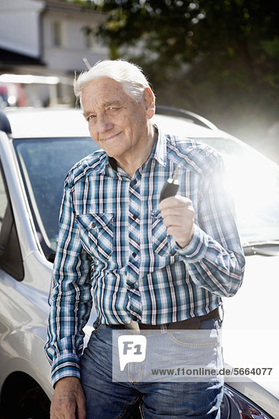 Porträt eines lächelnden älteren Mannes mit Autoschlüssel