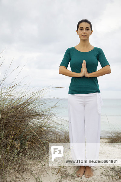 Reife Frau in Yogaposition am Strand  Portrait