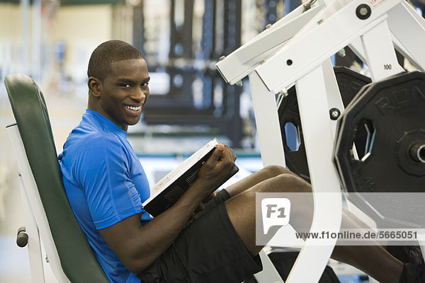 Young man lifting leg weights  portrait