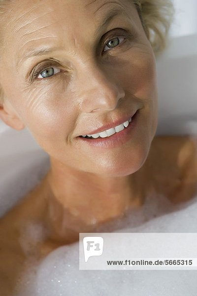 Mature woman relaxing in bubble bath  cropped