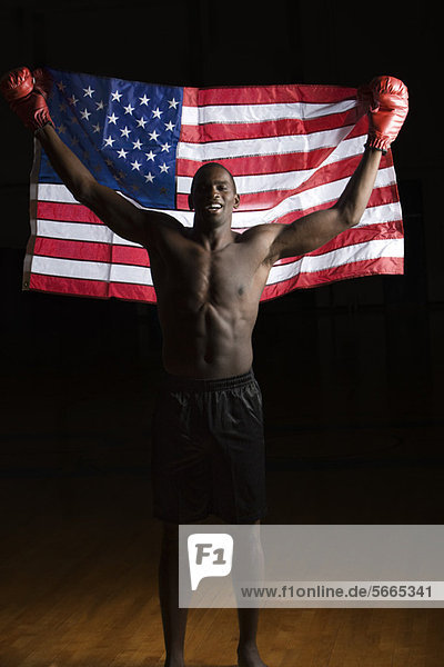 Boxer holding up American flag  portrait