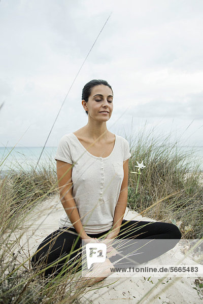 Reife Frau beim Meditieren am Strand  Portrait