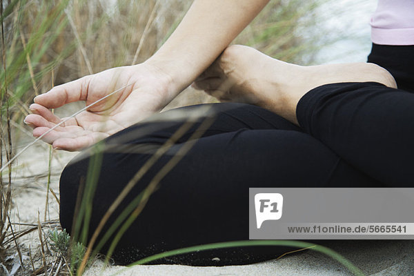 Frau sitzend in Lotusstellung  Finger in Meditationsstellung  beschnitten
