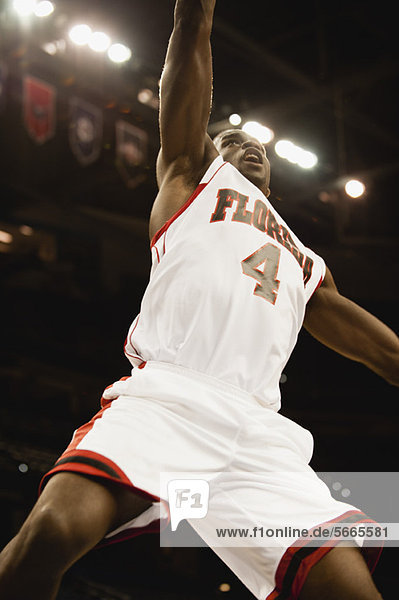 Basketballspieler beim Springen in der Luft  Blickwinkel niedrig