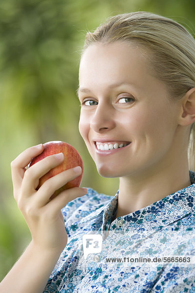 Lächelnde junge Frau mit Apfel  Portrait