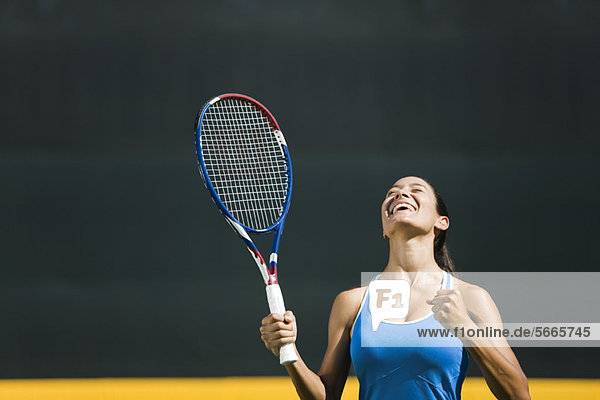Jubelnde junge Tennisspielerin  Portrait