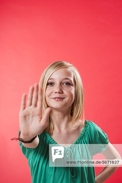 Teenagerin hebt ihre Hand zur Abwehr
