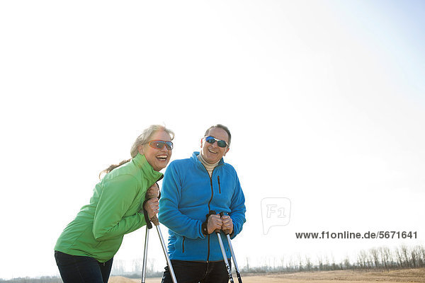 Fröhliches Paar macht Nordic Walking