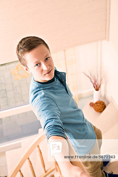Teenage boy  standing on stairs  at home