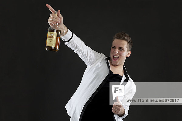 Junger Mann mit Whisky-Flasche