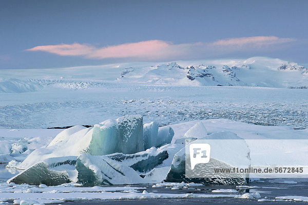 Schneebedeckte Eisberge driften auf der Gletscherlagune Jökuls·rlÛn  hinten die Gletscher Brei_amerkurjökull  Breidamerkurjökull und Vatnajökull  Vatnajökull Nationalpark  Island  Europa