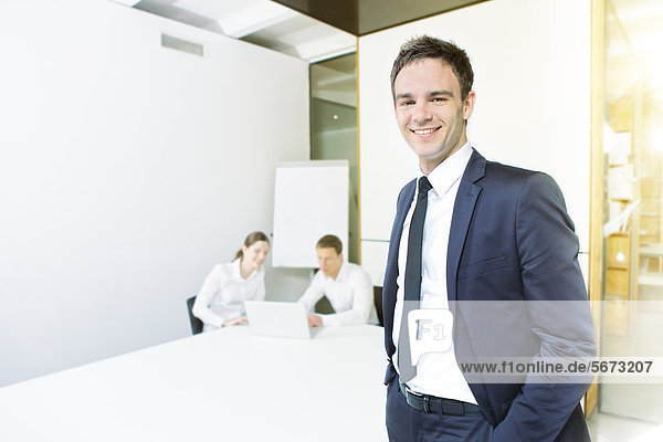 Lächelnder Geschäftsmann mit Geschäftsleuten im Büro