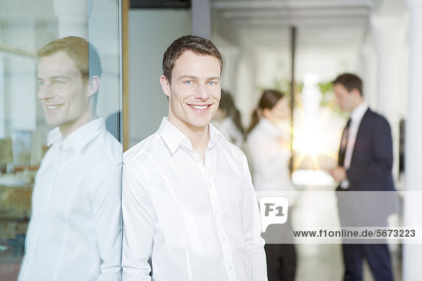 Smiling businessman with business people in office