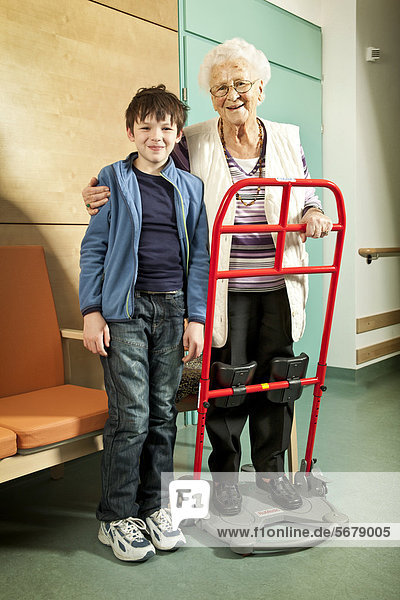 Seniorin mit Aufstehhilfe und Enkelkind  Pflegeheim  Rehabilitation