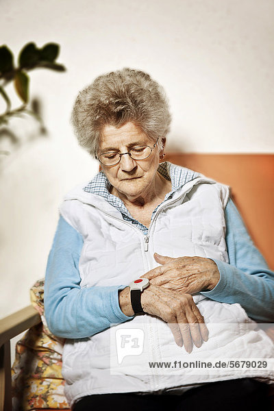 Seniorin mit Notrufsender am Handgelenk