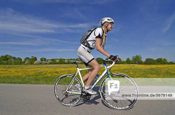 Young woman riding a racing bike  Upper Bavaria  Bavaria  Germany  Europe