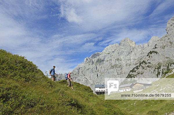 Hikers climbing a mountain  descending past Klamml towards Gruttenhuette mountain lodge  Ellmauer Halt  Wilder Kaiser mountain  Tyrol  Austria  Europe