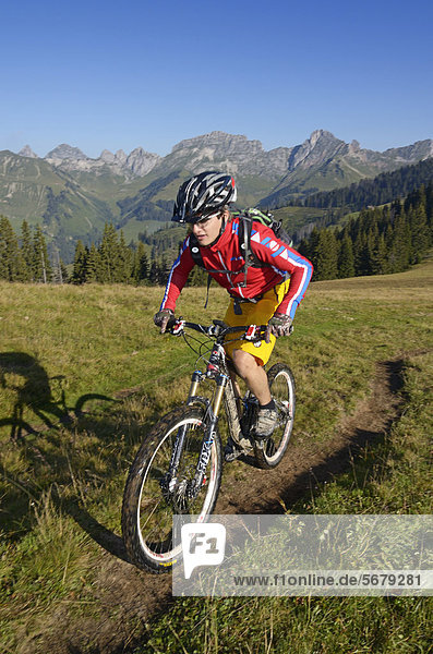 Mountain biker during the ascent of Mt Mittelberg  Hugeligrat ridge  Saanen  Gstaad  Municipality of Saanen  Bernese Oberland  Switzerland  Europe
