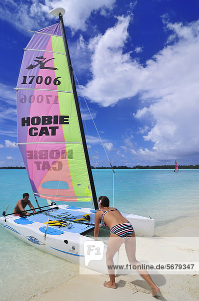 Tourists sliding catamaran into the sea  St. Regis Bora Bora Resort  Bora Bora  Leeward Islands  Society Islands  French Polynesia  Pacific Ocean