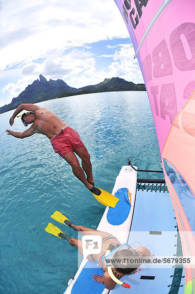 Tourists jumping from catamaran into the sea  St. Regis Bora Bora Resort  Bora Bora  Leeward Islands  Society Islands  French Polynesia  Pacific Ocean