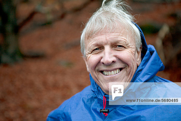 Senior man wearing waterproof clothing and smiling