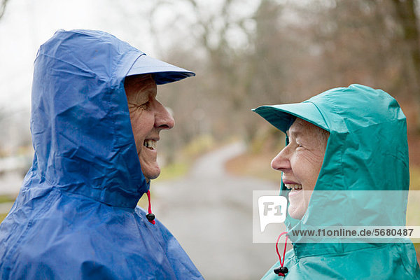 Senior couple face to face in waterproof clothing