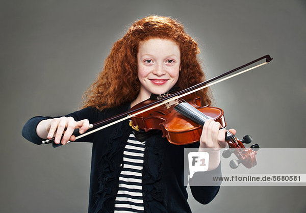 Portrait of mixed race teenage girl playing violin