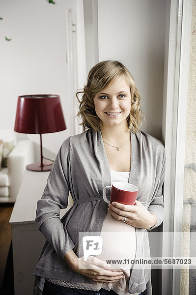 Schwangere Frau bei einer Tasse Kaffee
