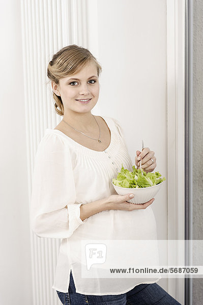 Schwangere Frau isst Salat
