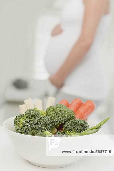 Schwangere Frau mit Gemüsebecher