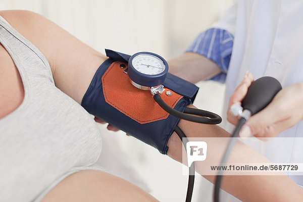Doktor  der womans Blutdruck nimmt