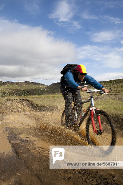 Man riding mountain bike in mud