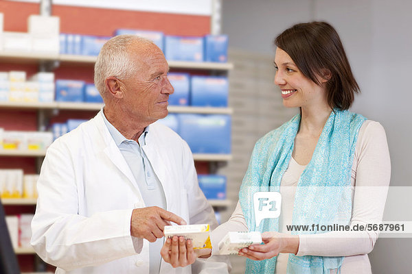 Pharmacist talking to patient in store
